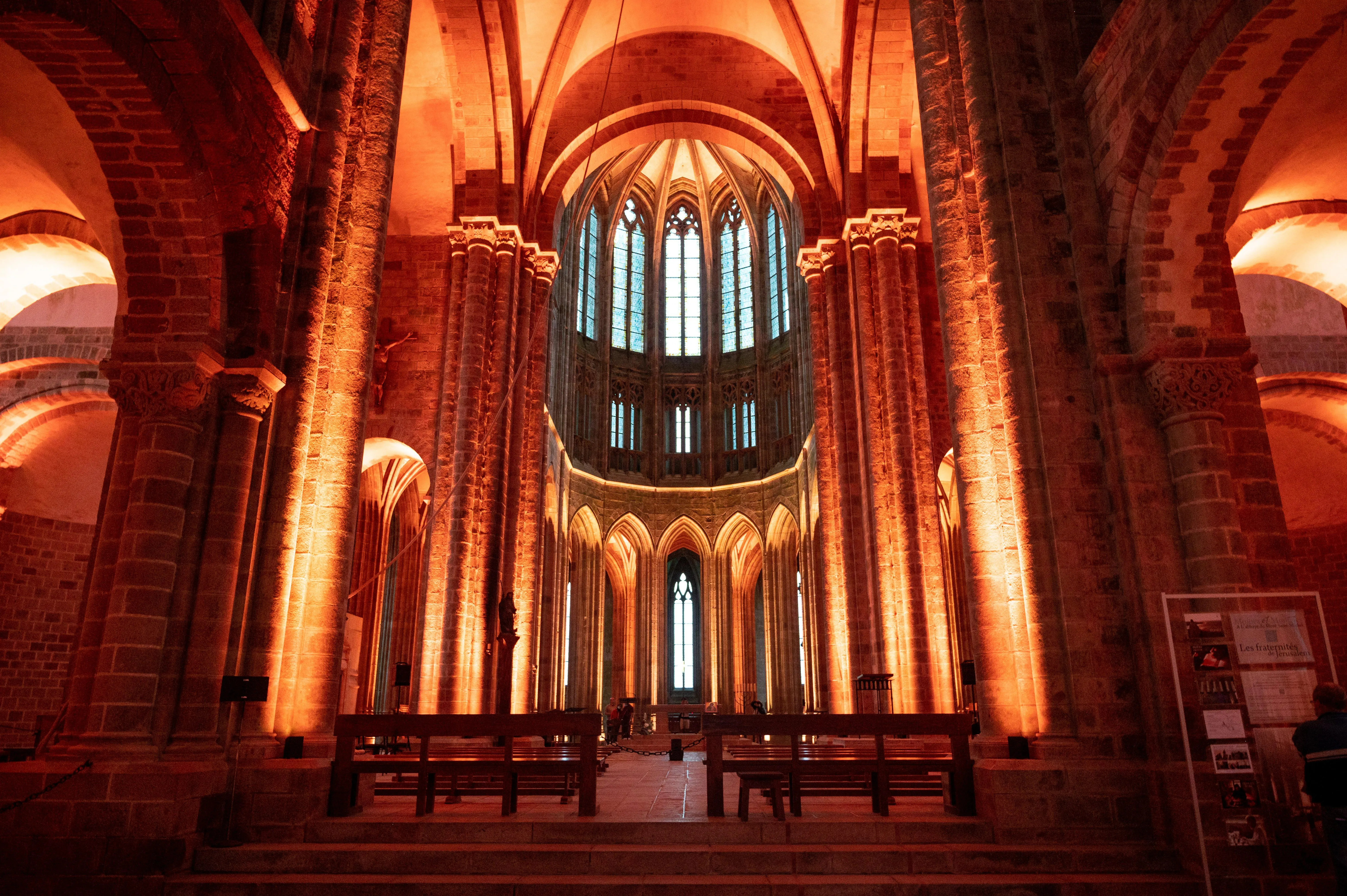 Early morning light filtering into the abbey church with few visitors seated in quiet reflection